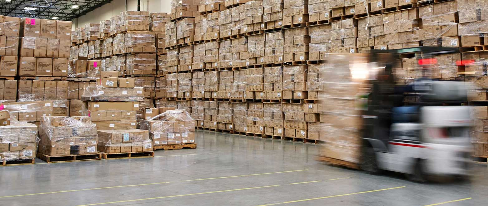 Warehouse aisles stacked with shipping boxes and a moving forklift